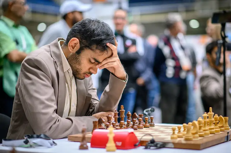 a man playing chess with his head in his hand